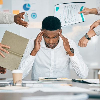 Employé stressé gérant simultanément plusieurs tâches et demandes au bureau