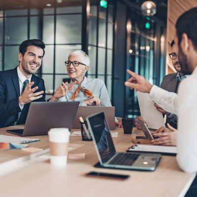 Groupe de professionnels discutant activement de stratégies commerciales autour d'une table de conférence