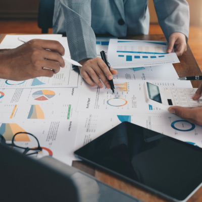 Deux professionnels analysant des graphiques financiers et des données de performance pour développer une stratégie d'entreprise