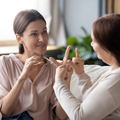 Deux femmes pratiquant la langue des signes, une communication non verbale, lors d'une session d'apprentissage